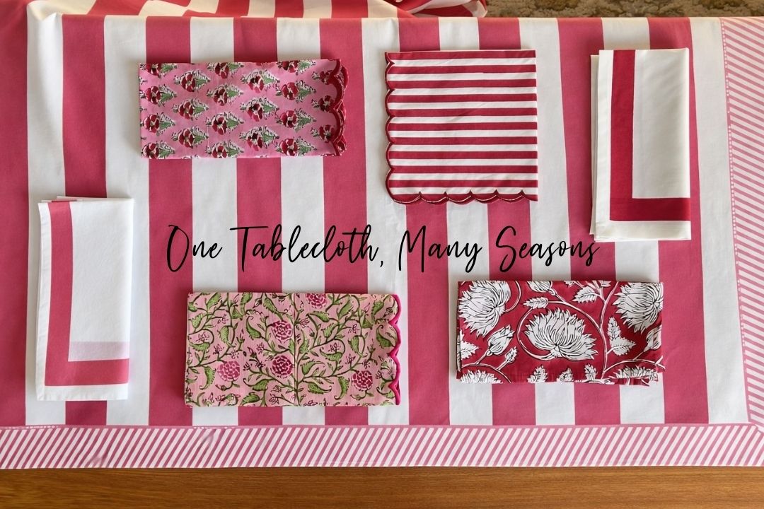 One pink and white tablecloth many seasons of use with various cloth napkin choices in shades of pink and red